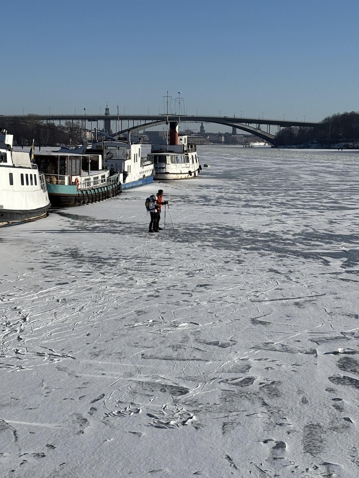 Boats frozen in place, with footprints all around them.